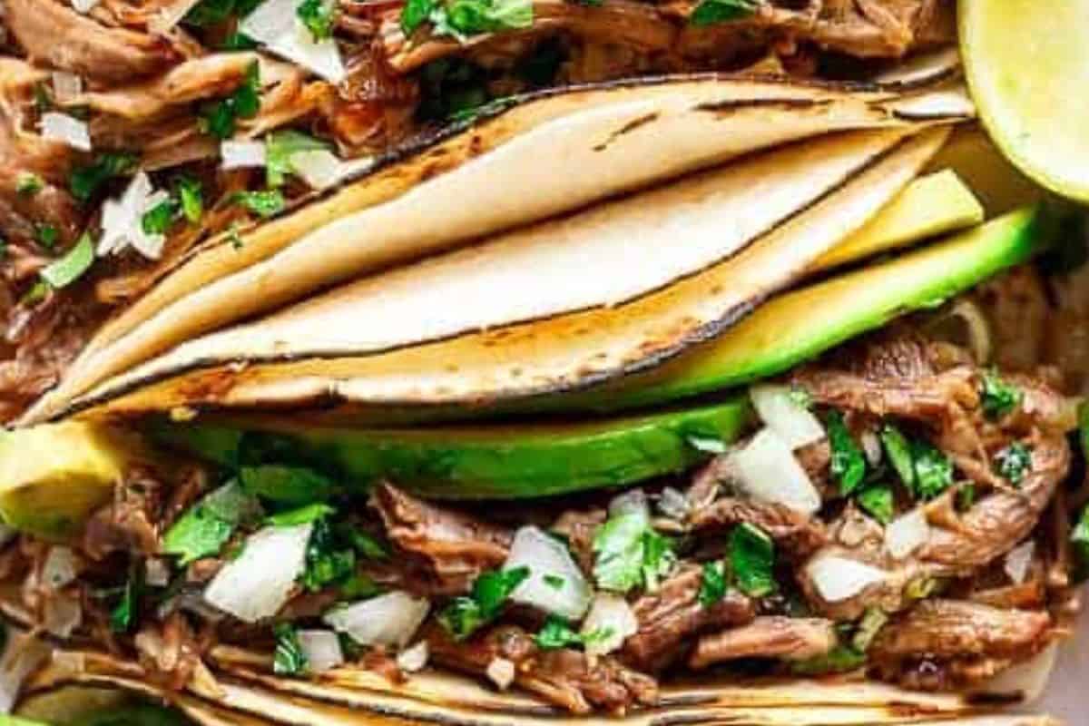 Fill the tortillas with beef and spoon over extra sauce. Top with avocado, onion, cilantro, and sour cream.