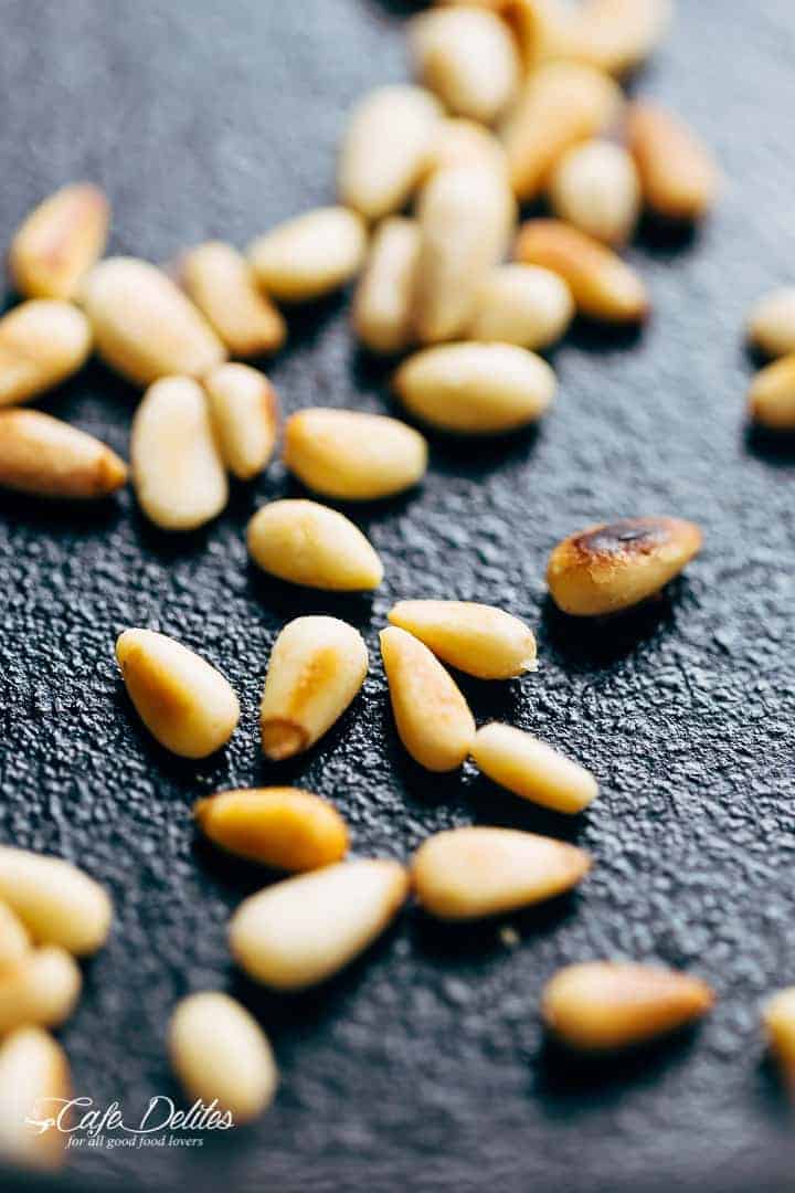 Close up image of roasted pine nuts on a plate. 