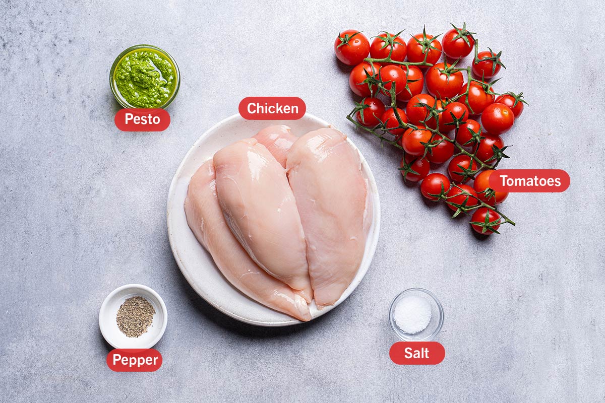 top down shot of chicken, pesto, tomatoes, pepper and salt