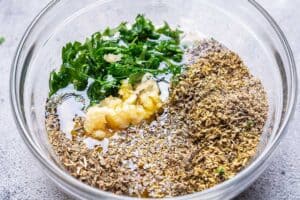 mixing bowel with minced garlic, herbs, olive oil, lemon juice, seasonings and vinegar.