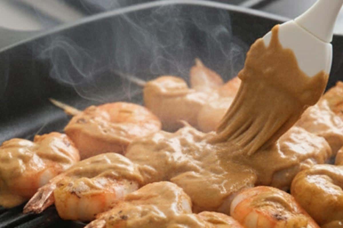 Grilling the shrimp and brush with sauce.