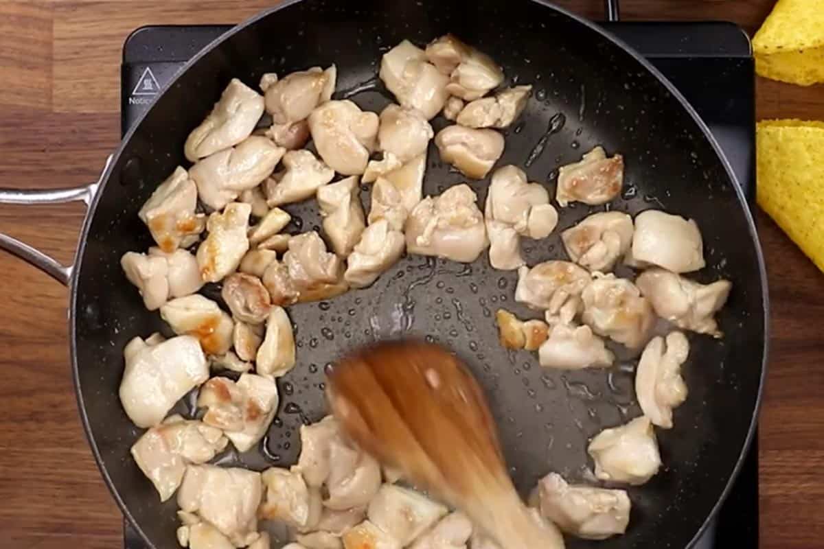 Searing the diced chicken in a skillet. - 4