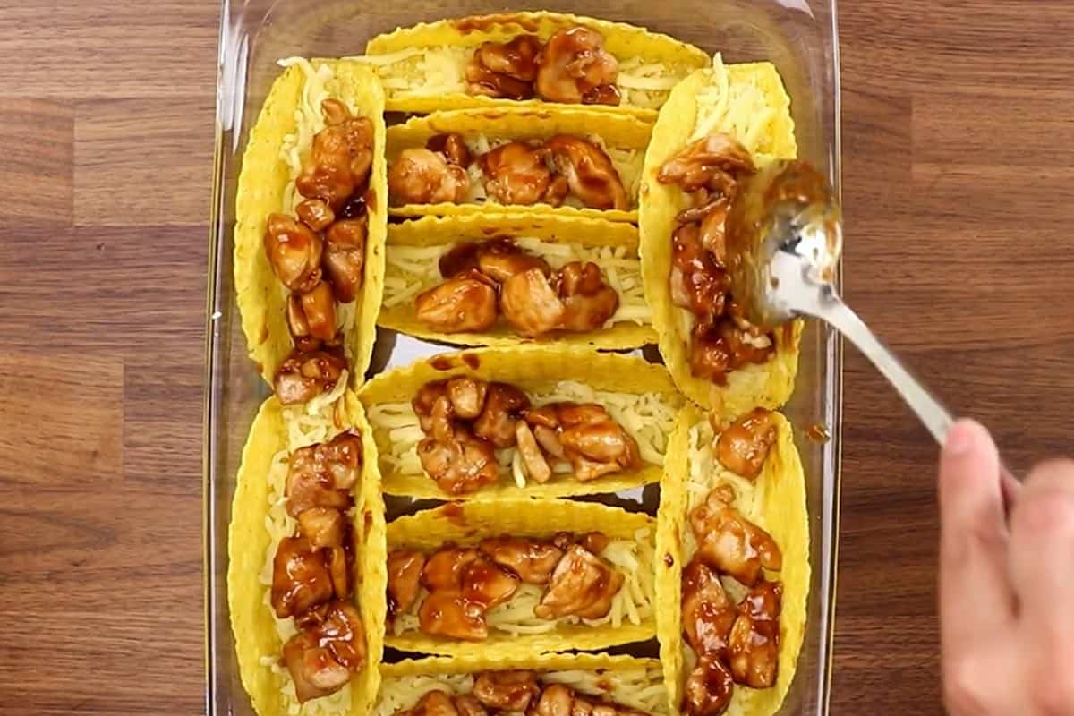 Filling the taco shells with chicken mixture. - 8