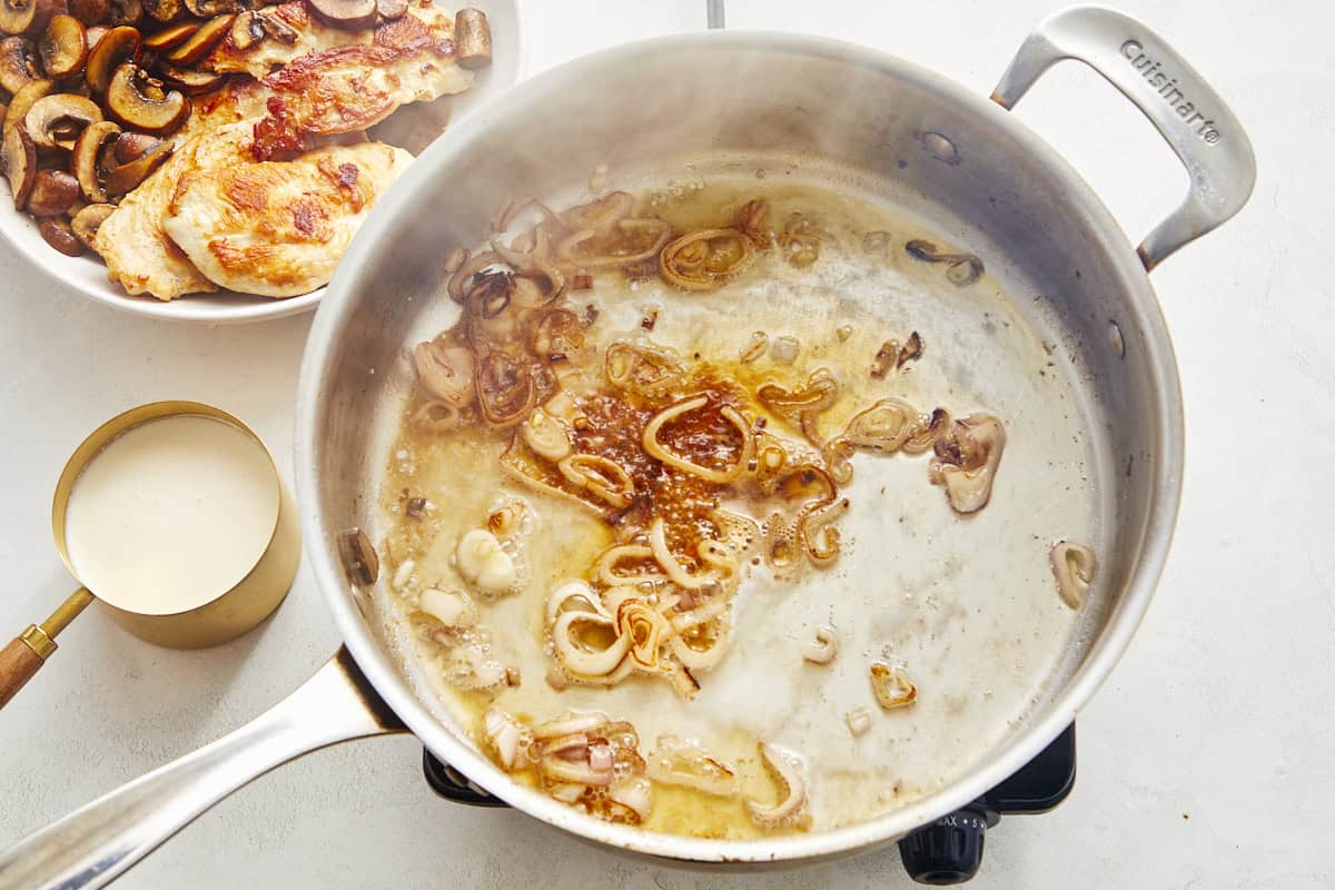 Shallots simmering in champagne until reduced by half.