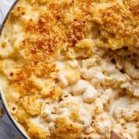 Garlic Parmesan Mac And Cheese is better than the original! A creamy garlic parmesan cheese sauce coats your macaroni, topped with parmesan fried bread crumbs, while saving some calories! | https://cafedelites.com