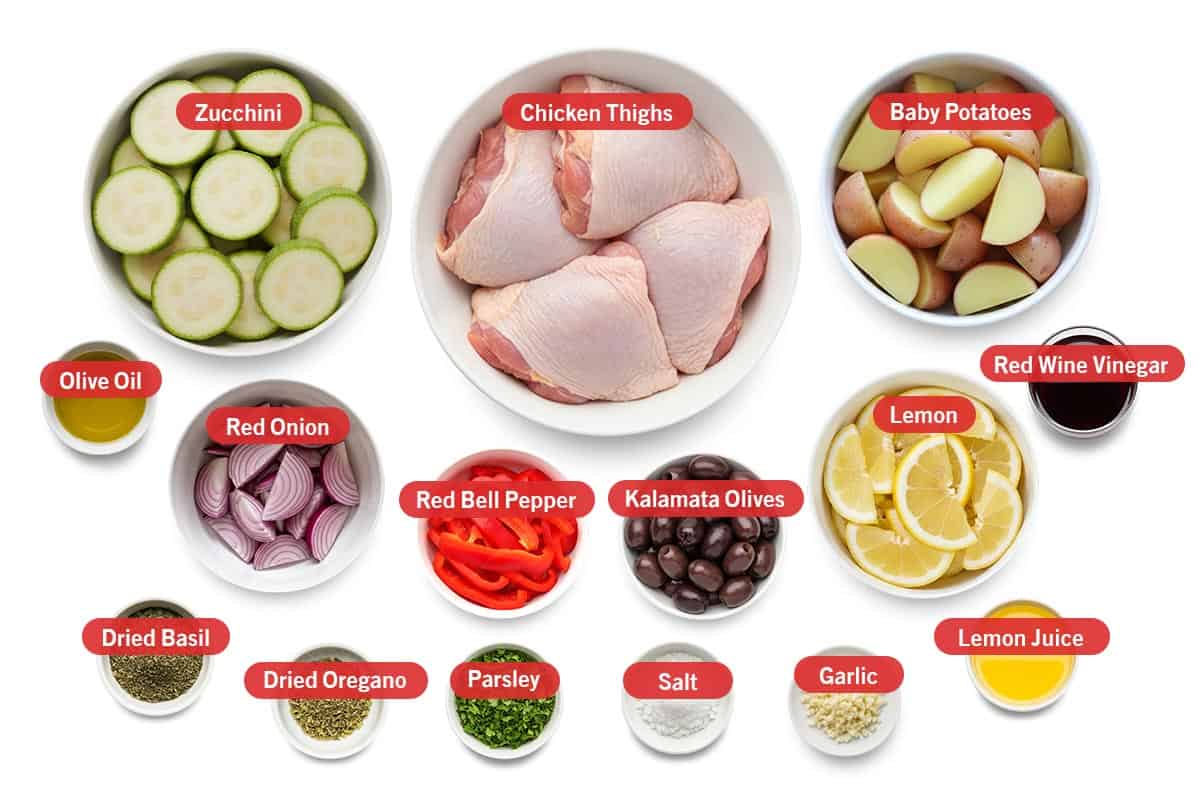 Top shot of ingredients: Zucchini, chicken thighs, baby potatoes, olive oil, red onion, red bell pepper, kalamata olives, lemon, red wine vinegar, dried basil, dried oregano, parsley, salt, garlic, and lemon juice.