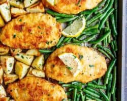 Oven baked and CRISPY breaded Sheet Pan Lemon Parmesan Garlic Chicken & Veggies, complete with potatoes and green beans smothered in a garlic butter sauce! | https://cafedelites.com