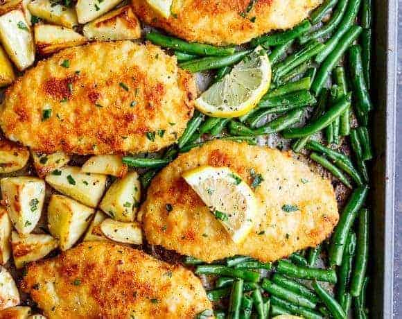 Oven baked and CRISPY breaded Sheet Pan Lemon Parmesan Garlic Chicken & Veggies, complete with potatoes and green beans smothered in a garlic butter sauce!