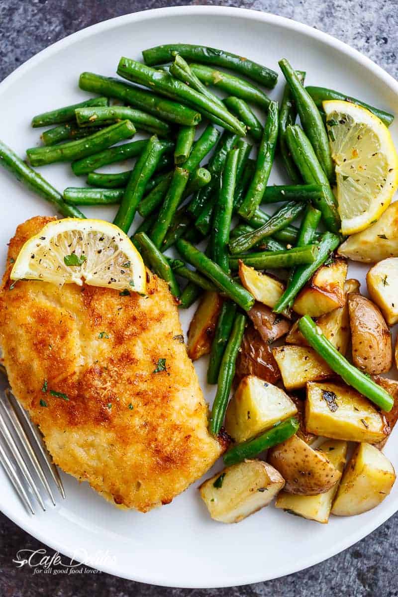 Oven baked and CRISPY breaded Sheet Pan Lemon Parmesan Garlic Chicken & Veggies, complete with potatoes and green beans smothered in a garlic butter sauce! | https://cafedelites.com