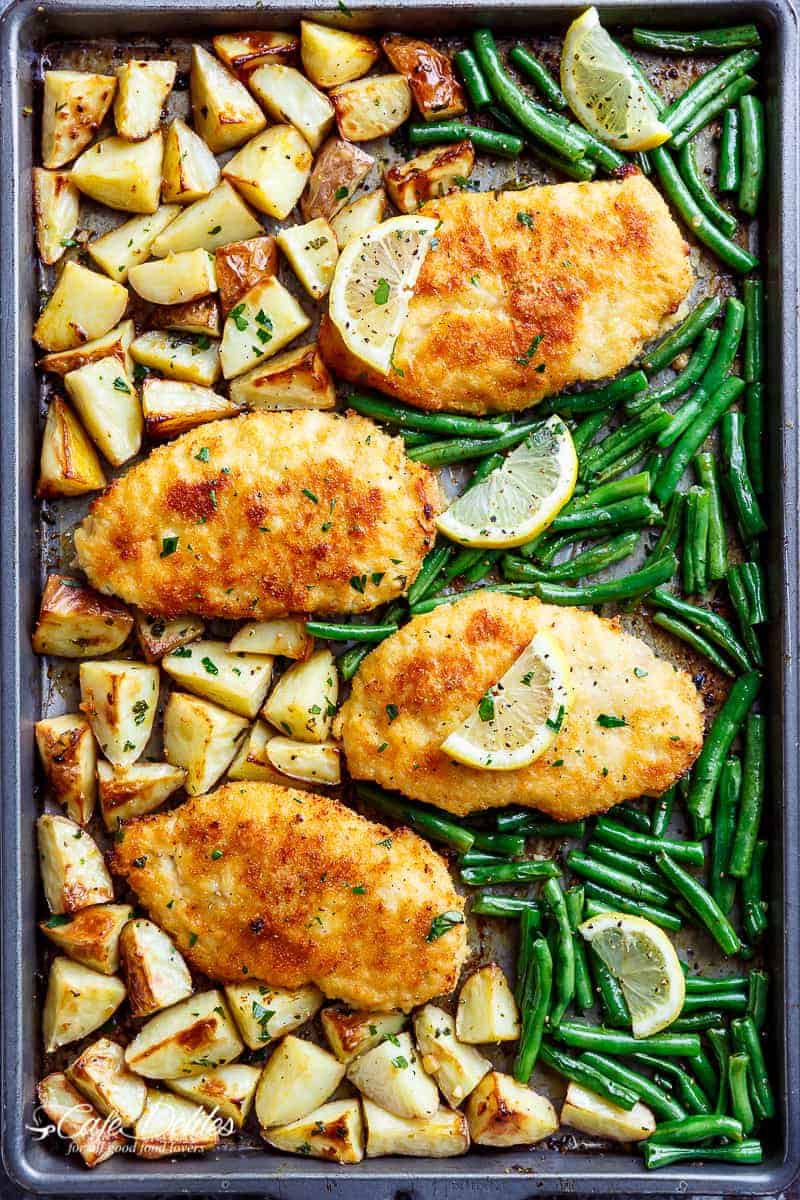 Oven baked and CRISPY breaded Sheet Pan Lemon Parmesan Garlic Chicken & Veggies, complete with potatoes and green beans smothered in a garlic butter sauce! | https://cafedelites.com