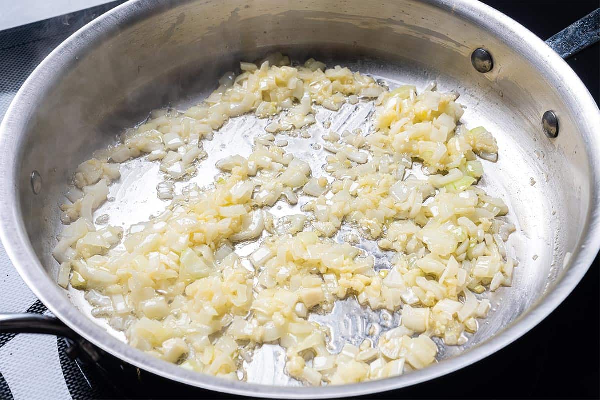 butter and onion  and garlic in a skillet being sauted