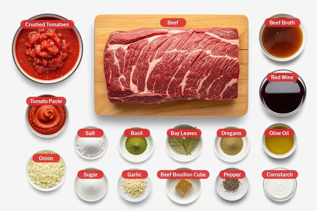 Top shot of ingredients: Crushed tomatoes, beef, beef broth, tomato paste, red wine, onion, salt, basil, bay leaves, oregano, olive oil, sugar, garlic, beef bouillon cube, pepper, and cornstarch.