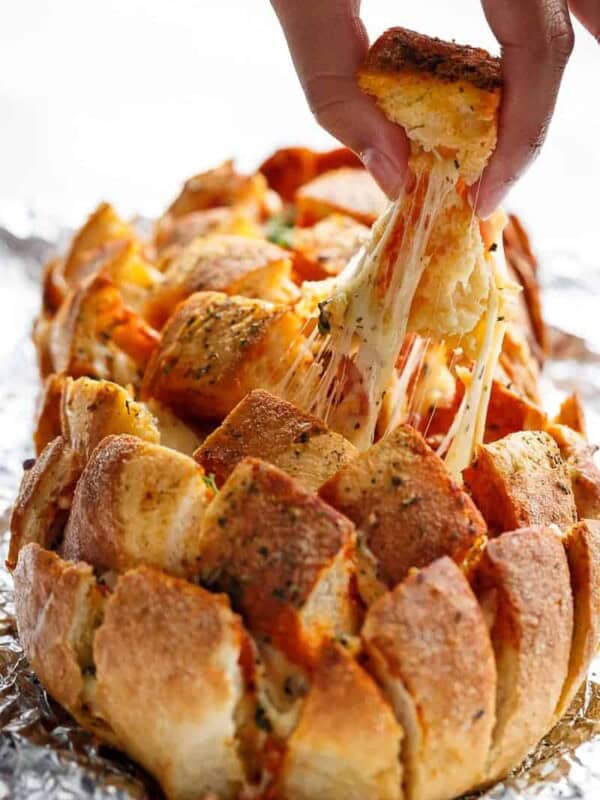 This Garlic Butter Pizza Pull Apart Bread is smothered in garlic butter, stuffed with pizza fillings, and topped with so.much.cheese!