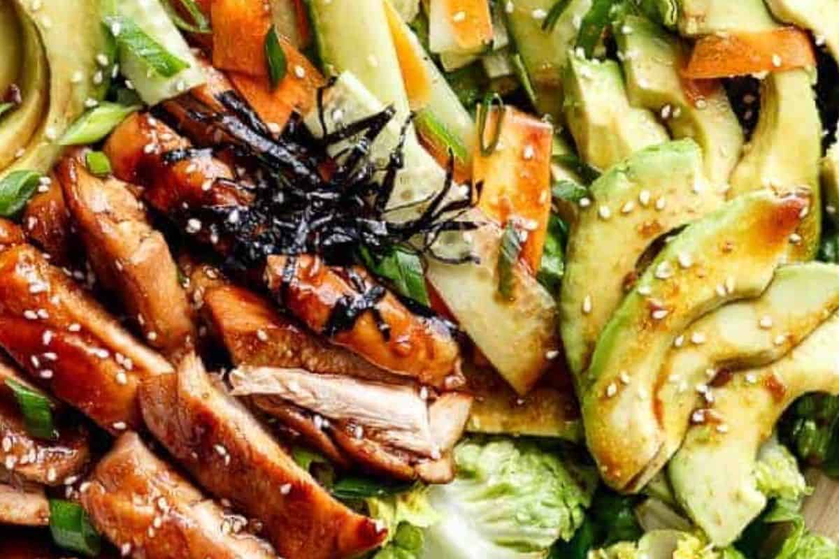 Arrange vegetables in a bowl, slice chicken over the top, add sesame seeds and seaweed and pour the dressing.