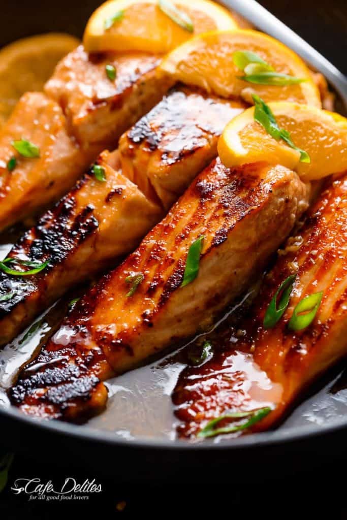 Crispy Honey Orange Glazed Salmon fillets are pan-fried in the most beautiful honey-orange-garlic sauce, with a splash of soy for added flavour! | https://cafedelites.com