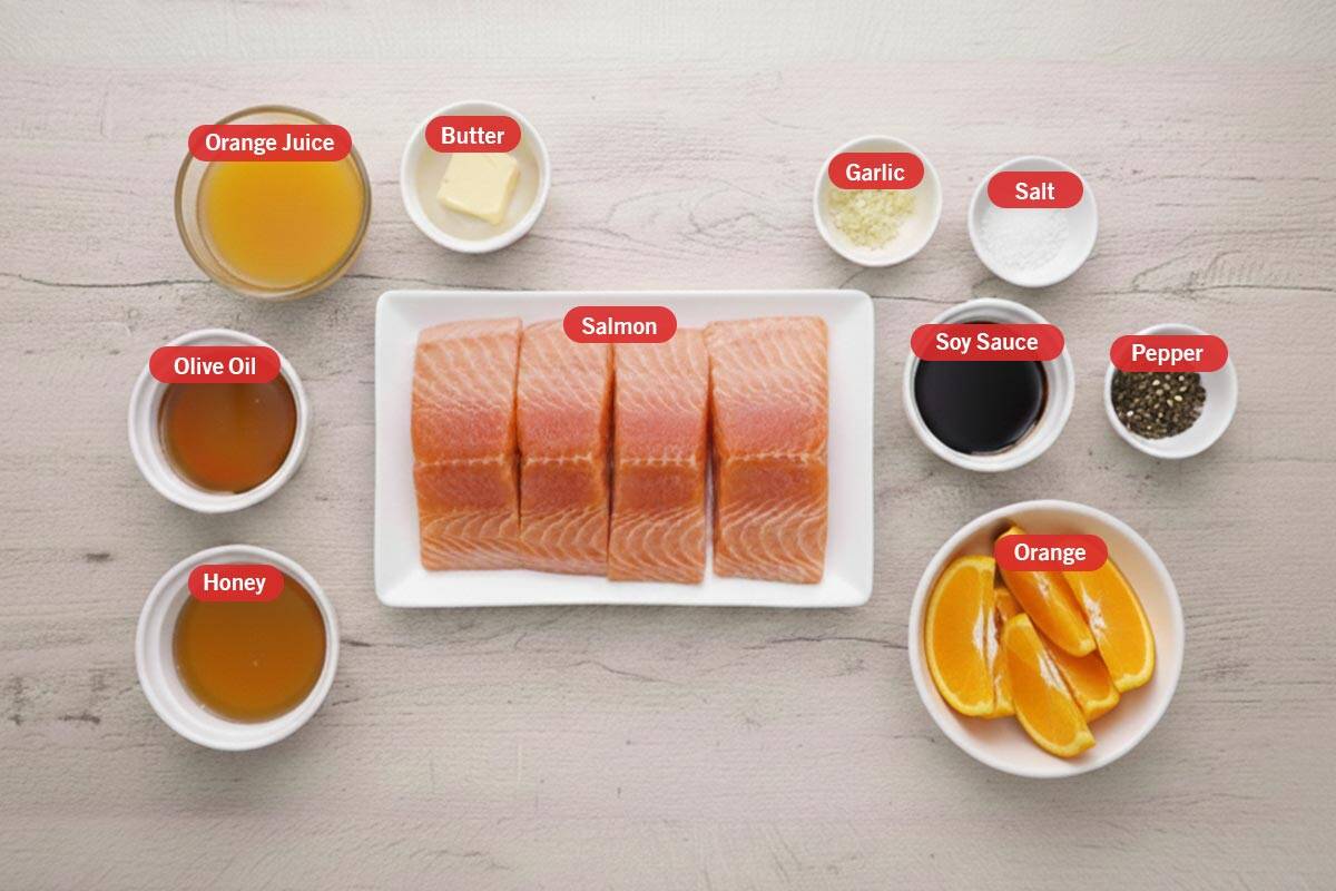 Top shot of ingredients: orange juice, butter, garlic, salt, soy sauce, pepper, orange, salmon, honey, and olive oil. - 2