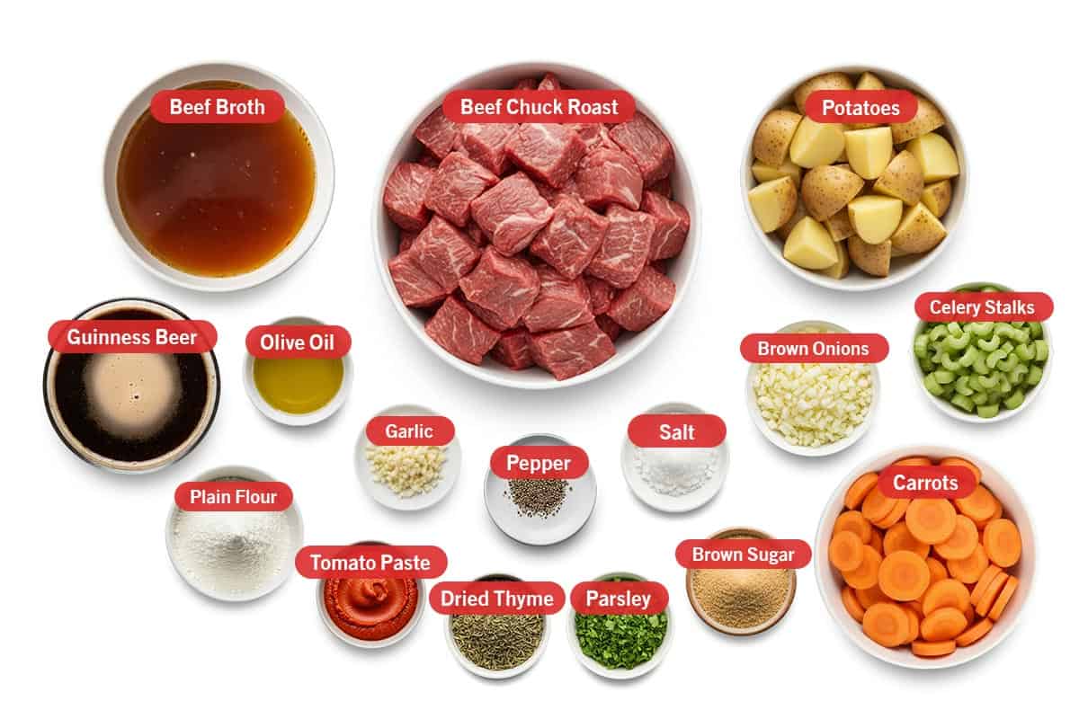 Top shot of ingredients: Beef broth, beef chuck roast, potatoes, guinness beer, olive oil, garlic, pepper, salt, brown onion, celery stalks, plain flour, tomato paste, dried thyme, parsley, brown sugar, and carrots.