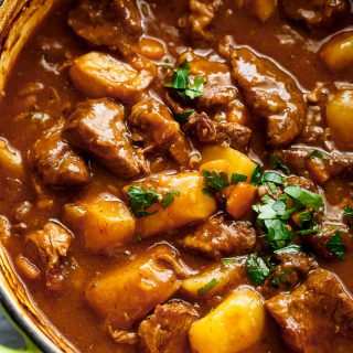 Beef And Guinness Stew is a heart warming bowl of comfort! Oven slow cooked beef, simmered in a rich Guinness gravy, with so much flavour! | https://cafedelites.com