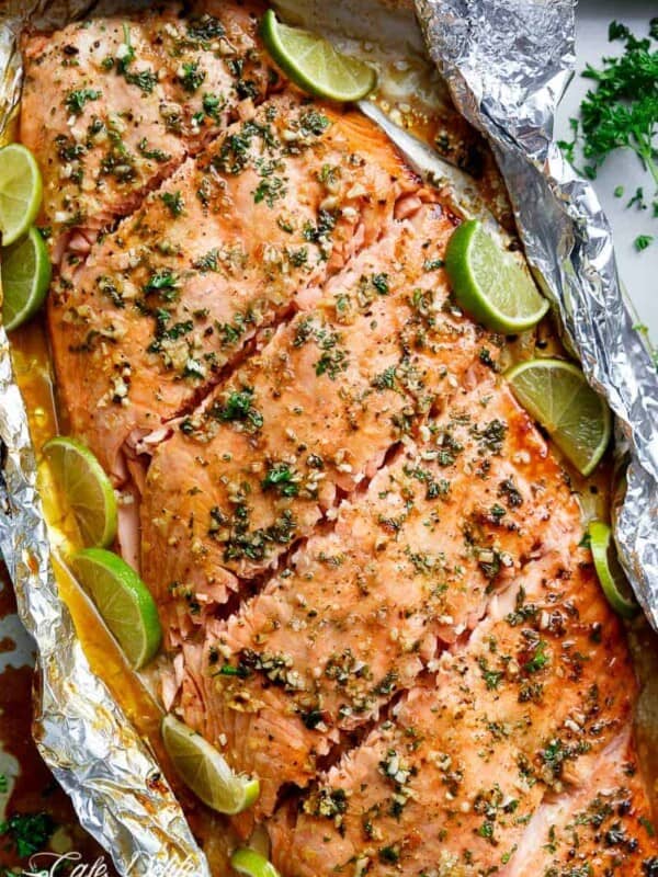 Top  view of Honey Lime Garlic Butter Salmon in foil with lemon wedges