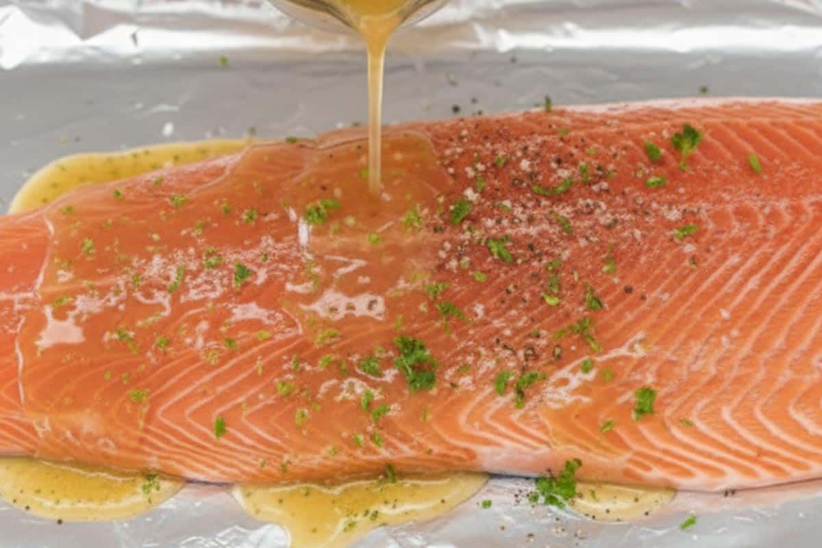 Pouring the honey-lime mixture on top of the salmon.