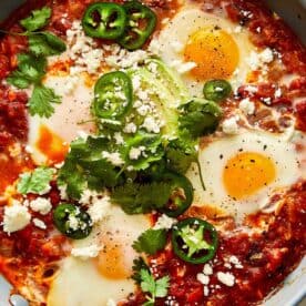 a top down view of a close up of a tomato and egg mixture with green jalapenos - 14