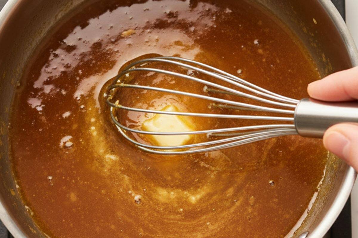 Whisking honey, soy sauce, and butter in a saucepan.