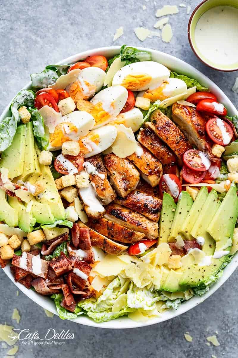 Grilled Chicken Cobb Caesar Salad is a meal in a salad, merging two of your favourites into one delicious bowl! Perfect for lunch or dinner! | https://cafedelites.com