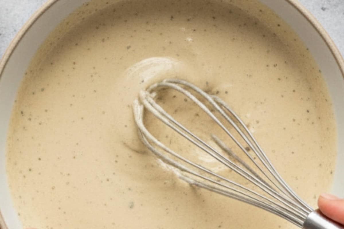 In a small bowl, whisk together mayonnaise, yogurt, olive oil, garlic, anchovies, lemon juice, and parmesan. Season with salt and pepper to taste.