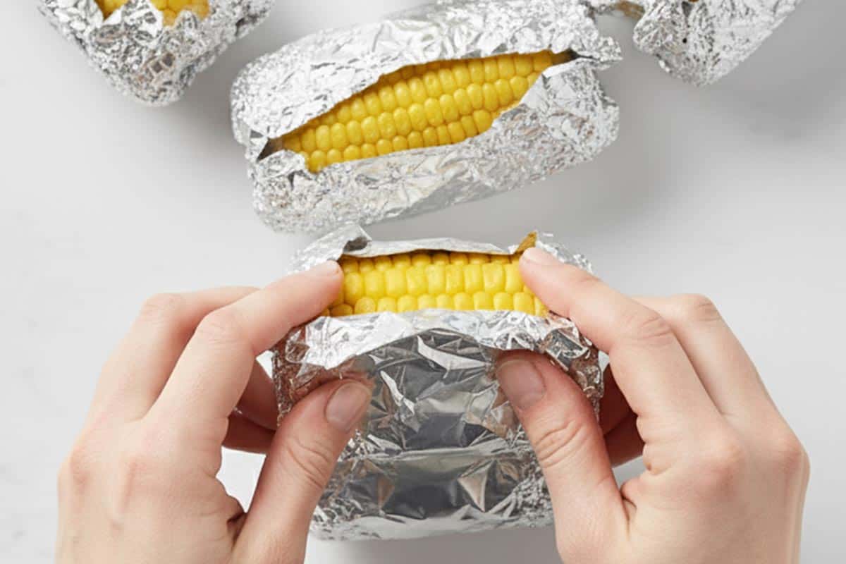 Wrapping the corn cobs with foil.
