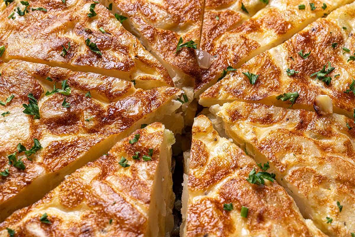 finished spanish omelette being garnished with parsley
