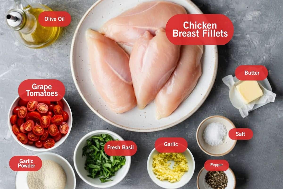 Flat lay photos of ingredient shot of olive oil. chicken breast fillets, grape tomatoes, garlic powder, fresh basil, garlic, salt, pepper, butter