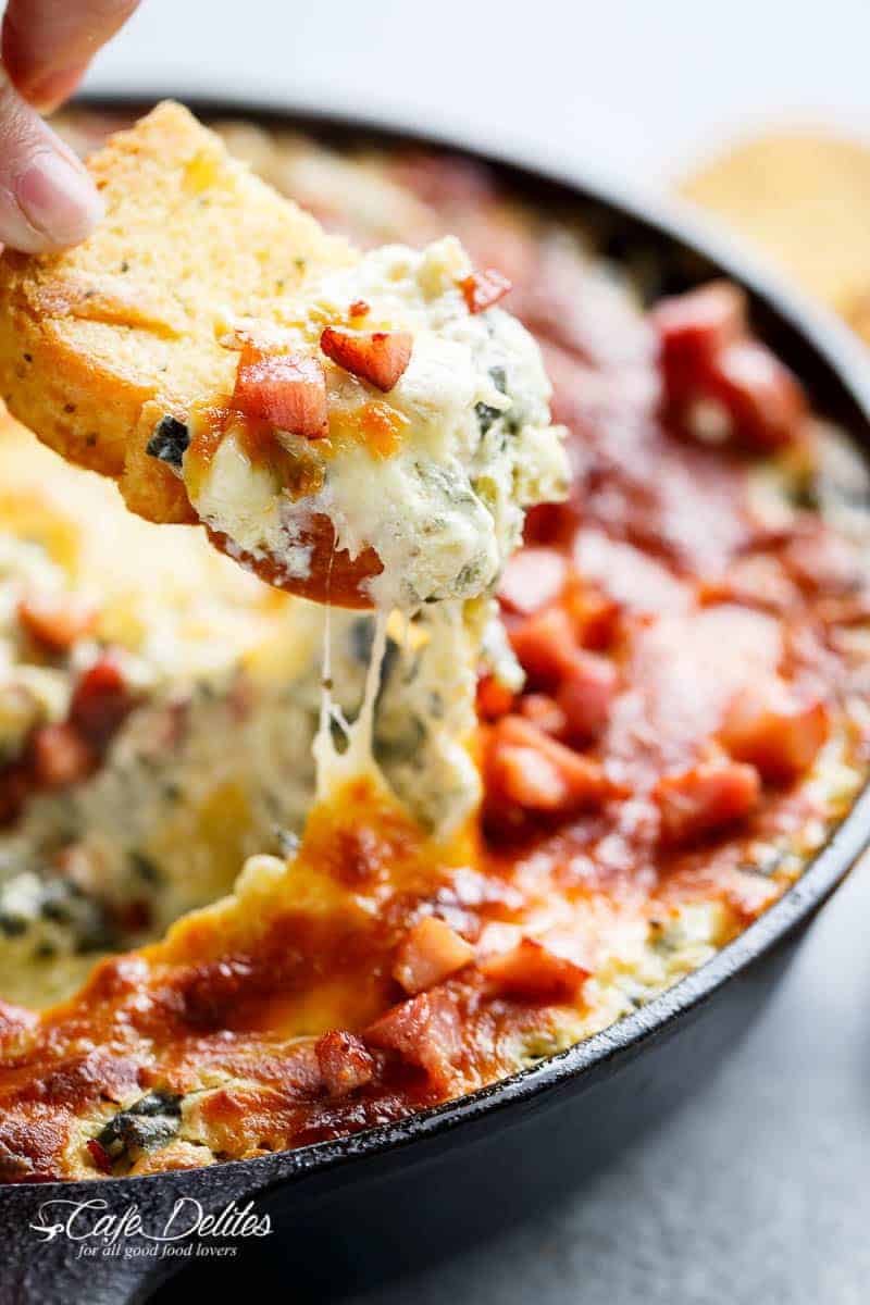 Warm Spinach Bacon Artichoke Dip is a hit around the table! Made with minimal ingredients and topped with crispy bacon, what's not to love! | https://cafedelites.com