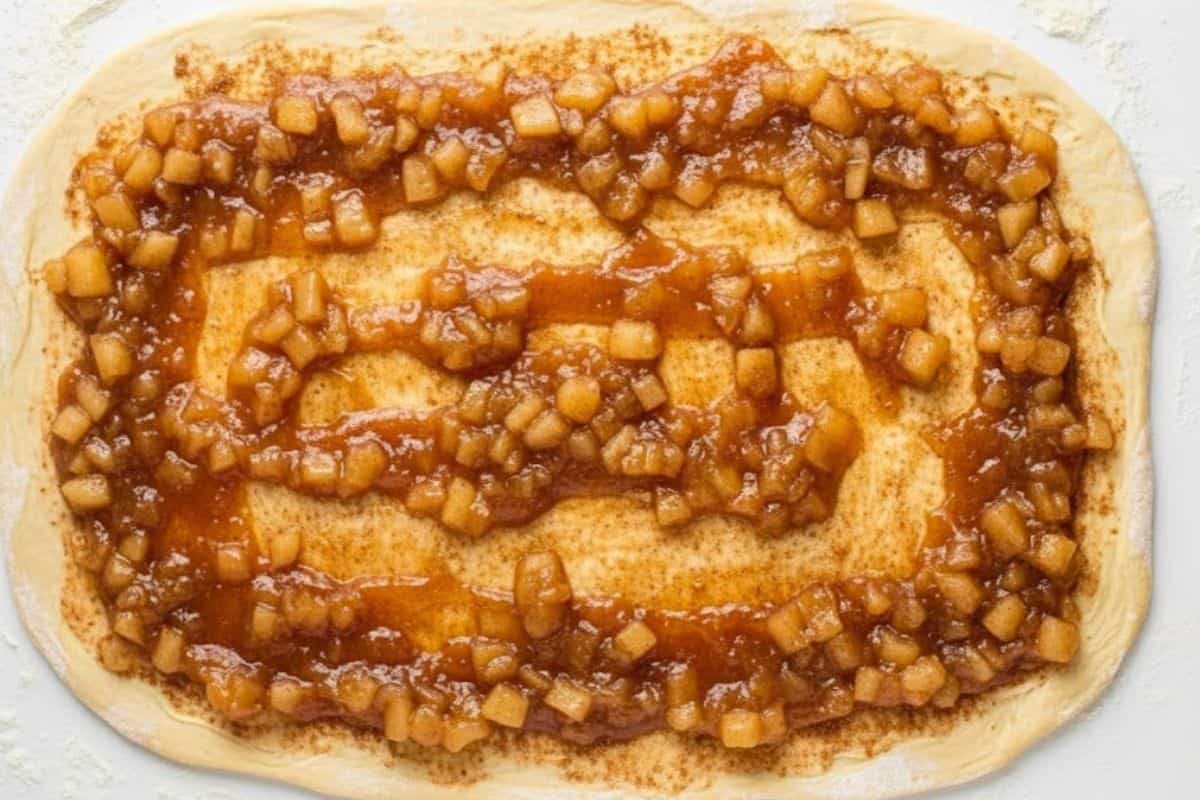 oll out the dough on a lightly floured surface into a 21×14-inch rectangle. Brush with melted butter, sprinkle with brown sugar and cinnamon, and gently rub the mixture in.