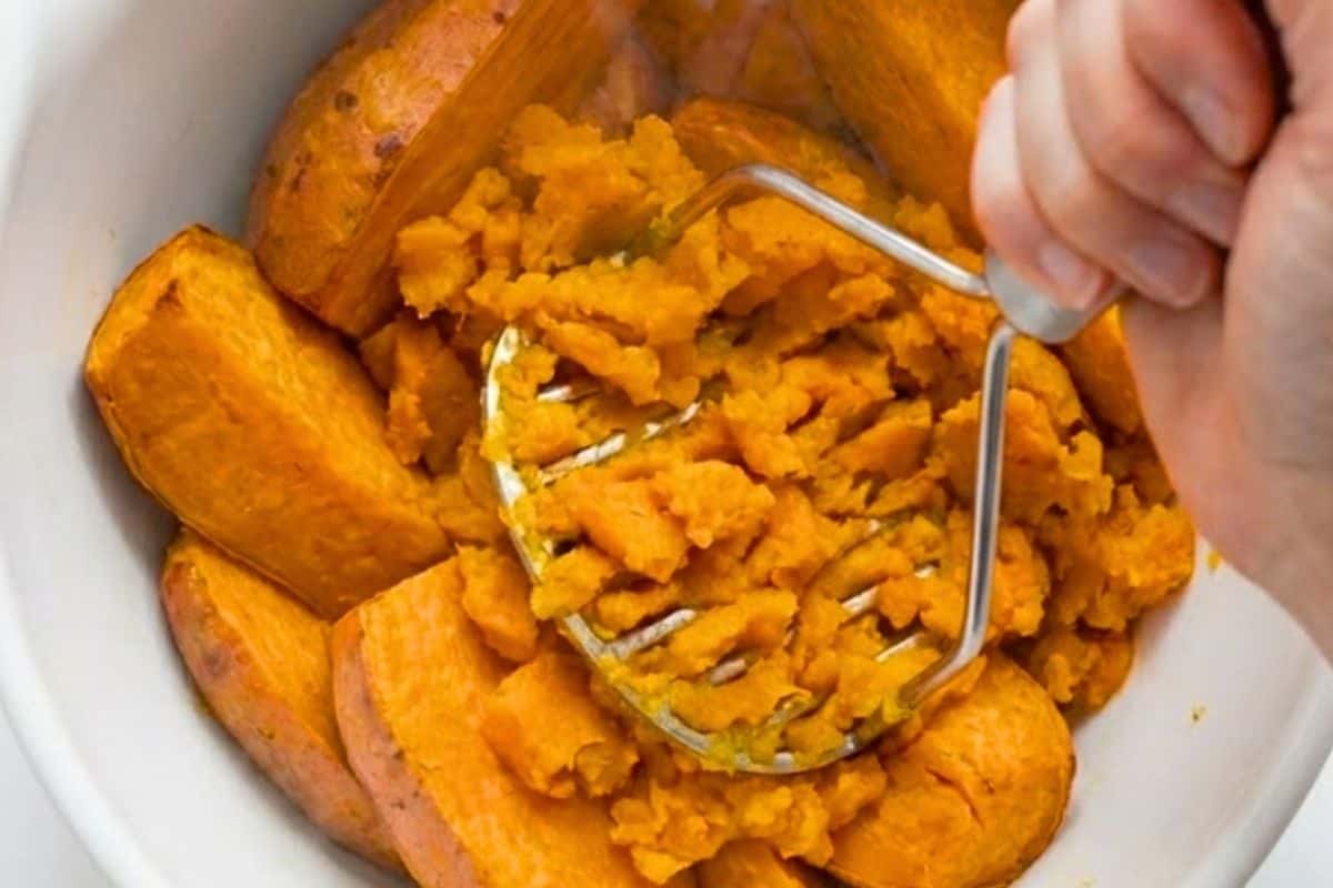 Transfer the cooked sweet potatoes to a mixing bowl and mash until smooth with a potato masher