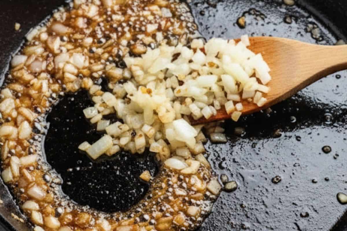 Add onion and the remaining garlic to the same pan with the leftover sauce and stir for 1 minute.