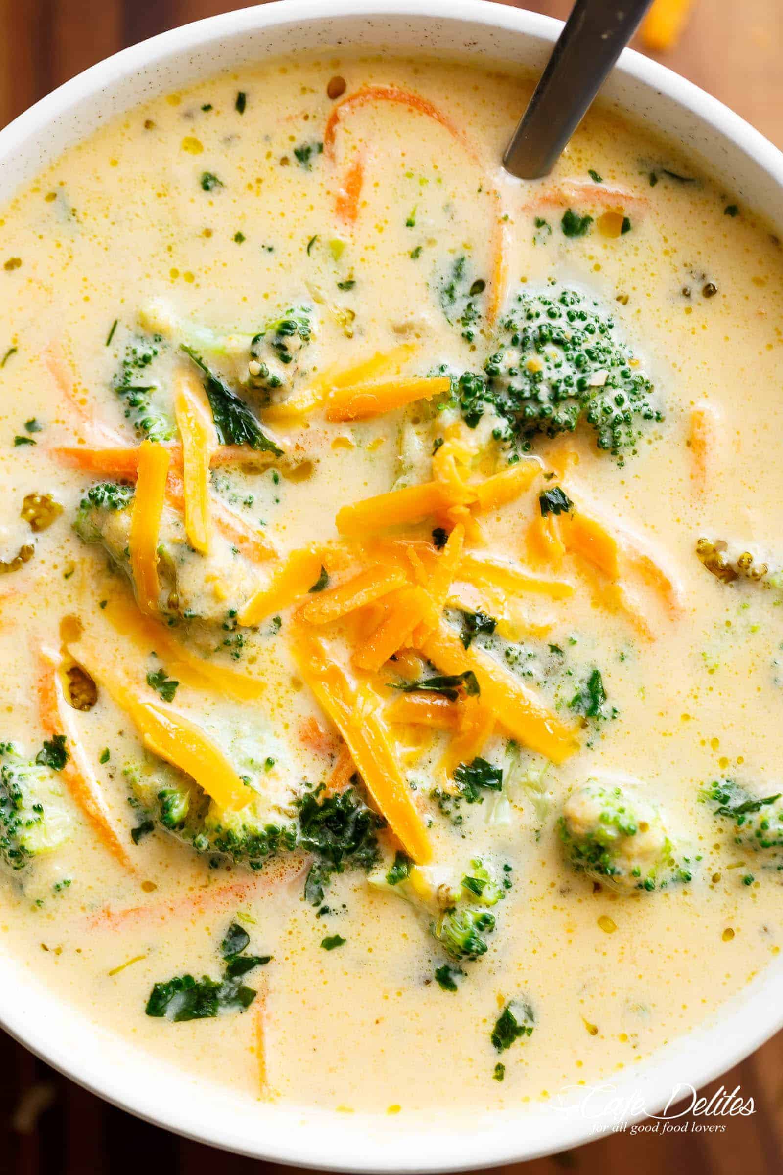 A close up of Broccoli Cheese Soup in a bowl with grated cheese on top. 