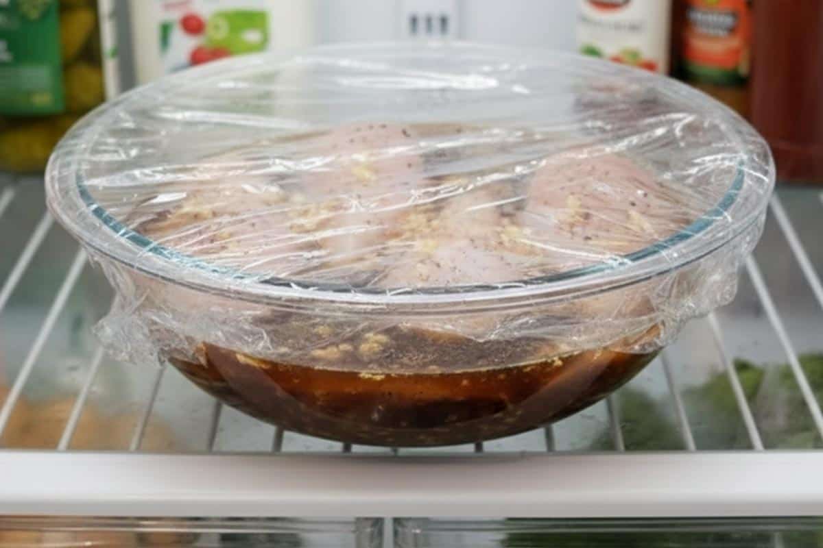 Marinating the chicken with lager, garlic, salt, and pepper in a bowl. - 3