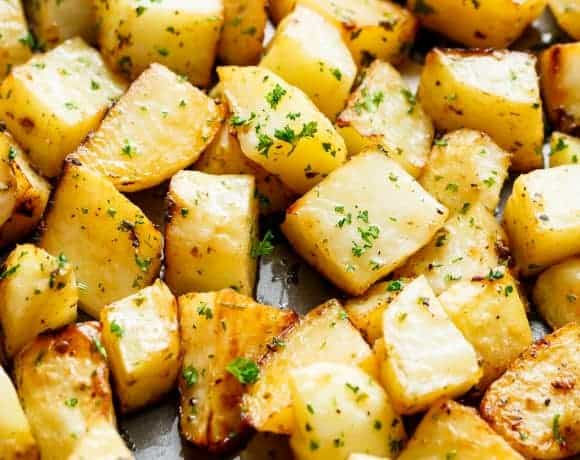 Crispy Garlic Roasted Potatoes are a super simple side dish perfect with anything! Buttery, garlicky, fluffy inside and and crispy edges. These potatoes tick all my boxes! No need for bowls or pans when you can prepare AND cook your potatoes on ONE PAN! | cafedelites.com