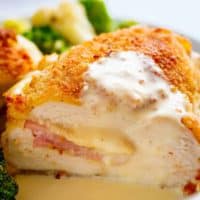 Easy Sheet Pan Chicken Cordon Bleu is a complete dinner for the entire family! Crispy crumbed chicken breasts filled with Dijon mustard, Swiss cheese and ham, baked with vegetables and served with an incredible Dijon Cream Sauce for the ultimate restaurant feel right at home!