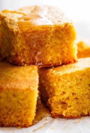 Side view image of Easy Buttermilk Cornbread with a hint of honey is the perfect side to chili's, soups or stews! Crunchy buttery edges with a soft and fluffy centre!