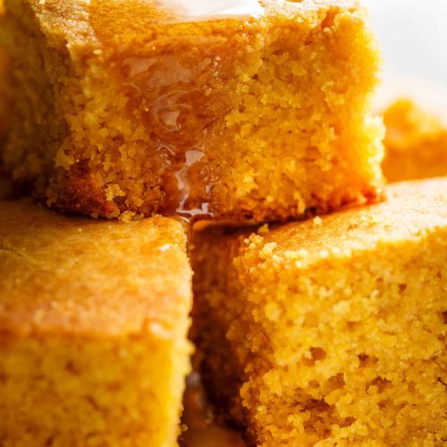 Side view image of Easy Buttermilk Cornbread with a hint of honey is the perfect side to chili's, soups or stews! Crunchy buttery edges with a soft and fluffy centre!