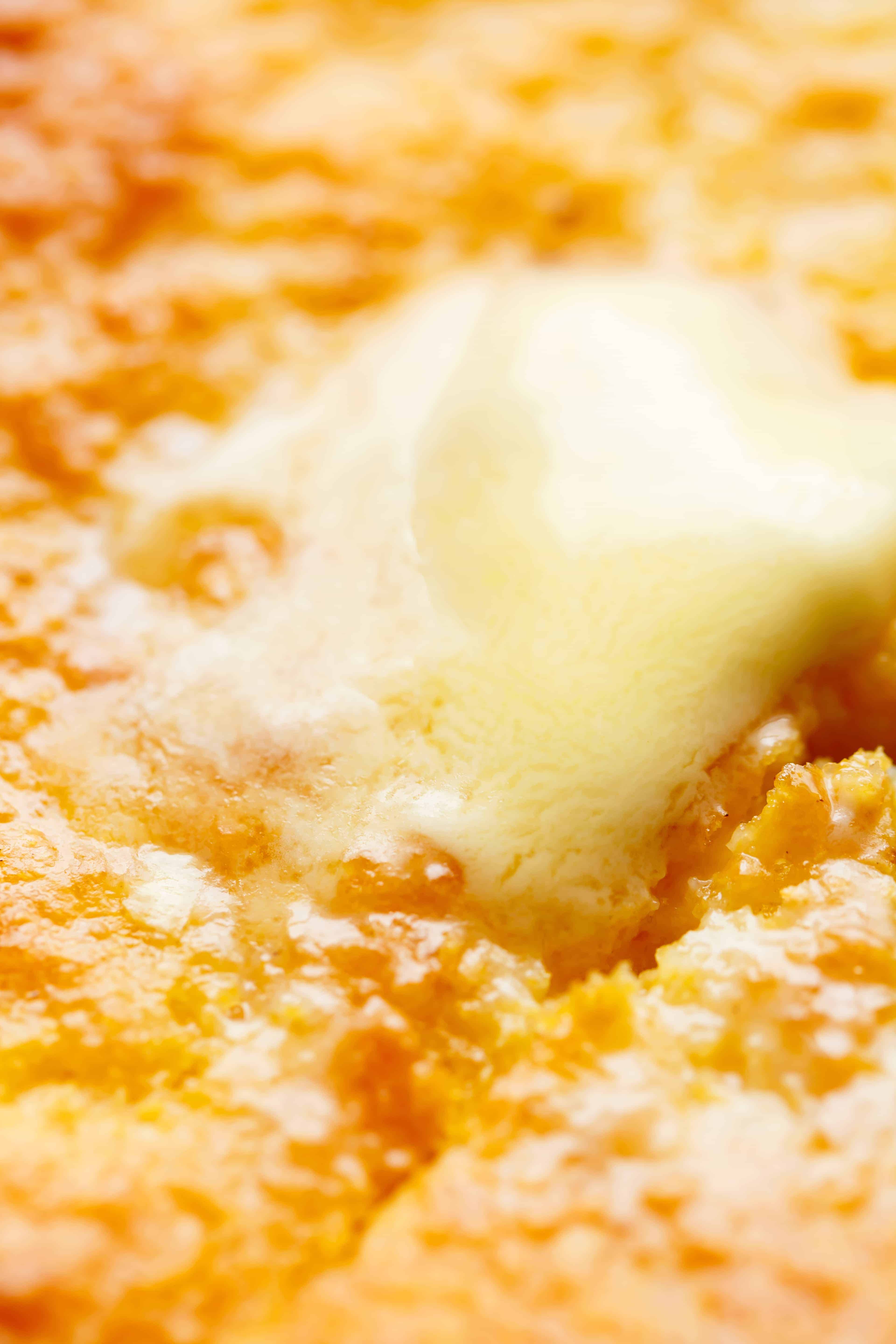 Close up of butter melting on the golden moist surface of sweet buttermilk cornbread.