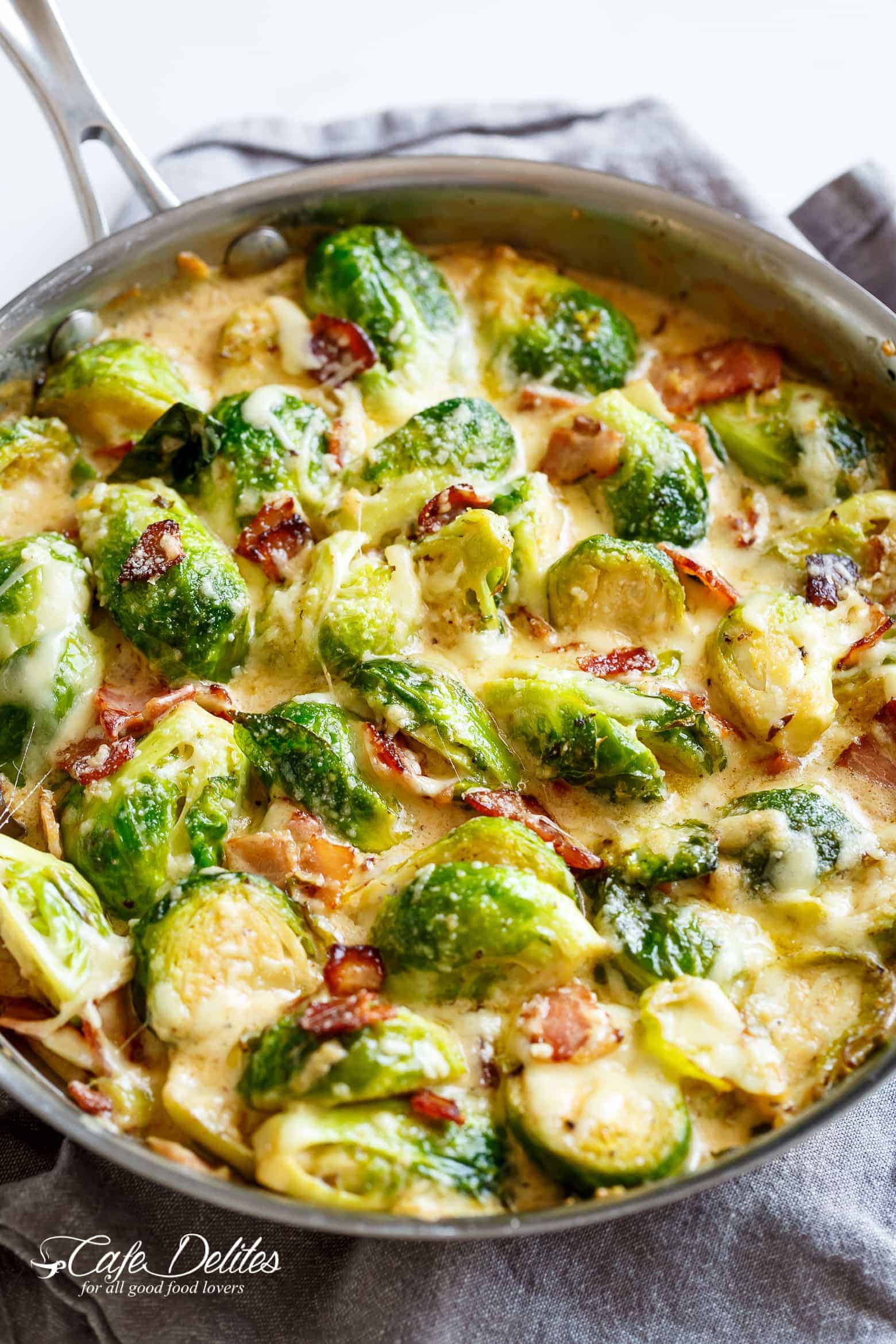 Creamy Garlic Parmesan Brussels Sprouts & Bacon will become your NEW favourite way to eat Brussels Spouts! Pan fried Brussels sprouts and bacon baked in a cheesy creamy garlic sauce, and topped with bubbling mozzarella and parmesan cheese!