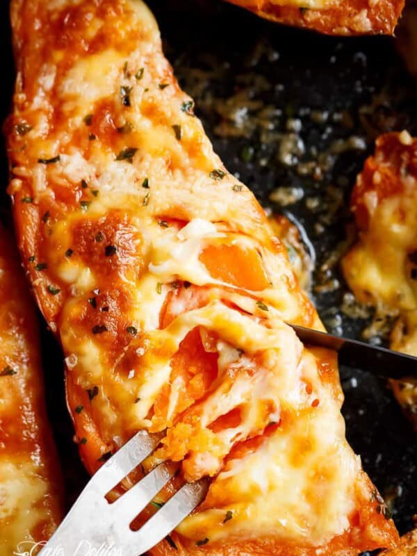 Mozzarella cheese and parmesan top these tender garlic butter smothered sweet potatoes with fork