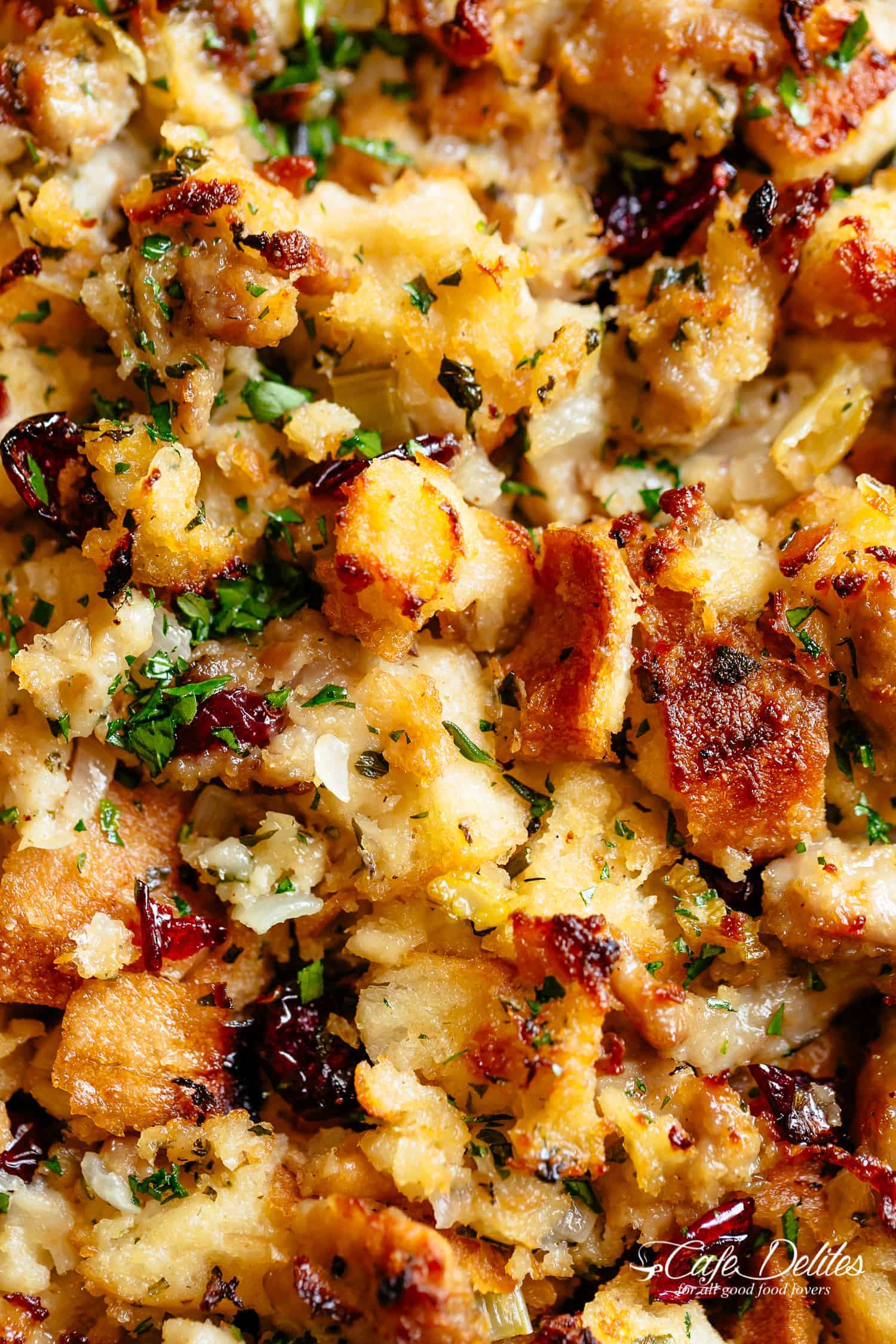 Close up of golden toasted bread stuffing with herbs and dried cranberries mixed in.