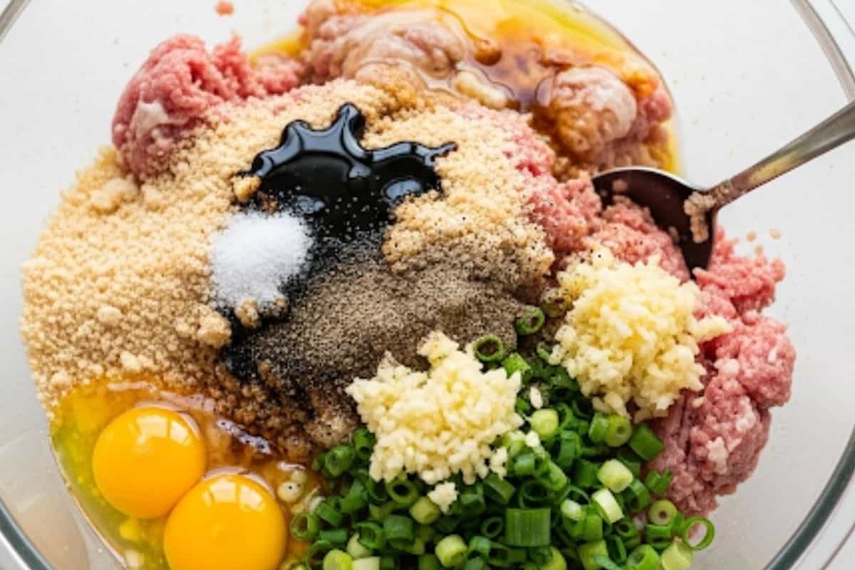 Combine meat, breadcrumbs, eggs, scallions, garlic, soy sauce, sake, salt, and pepper in a large bowl.