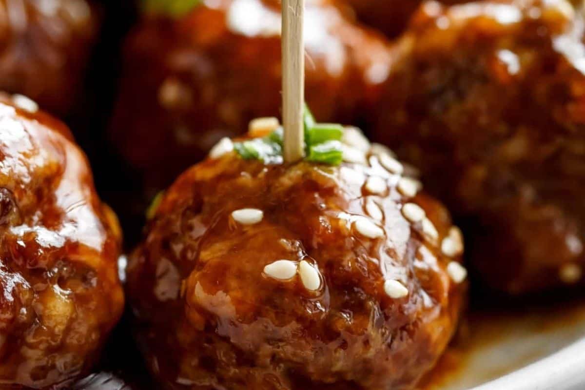 Pour about three quarters of the sauce over the hot meatballs and toss gently to coat. Garnish with sesame seeds and green onion.