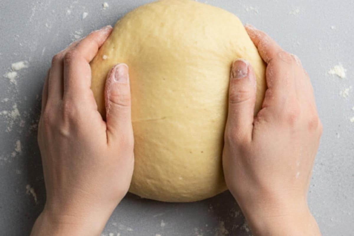 Turn the dough out onto your floured surface and knead gently with damp hands until it forms a smooth ball.