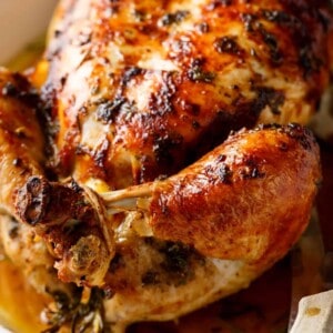 Garlic Herb Butter Roast Chicken packed with unbelievable flavors, crispy skin, and juicy on a white serving plate