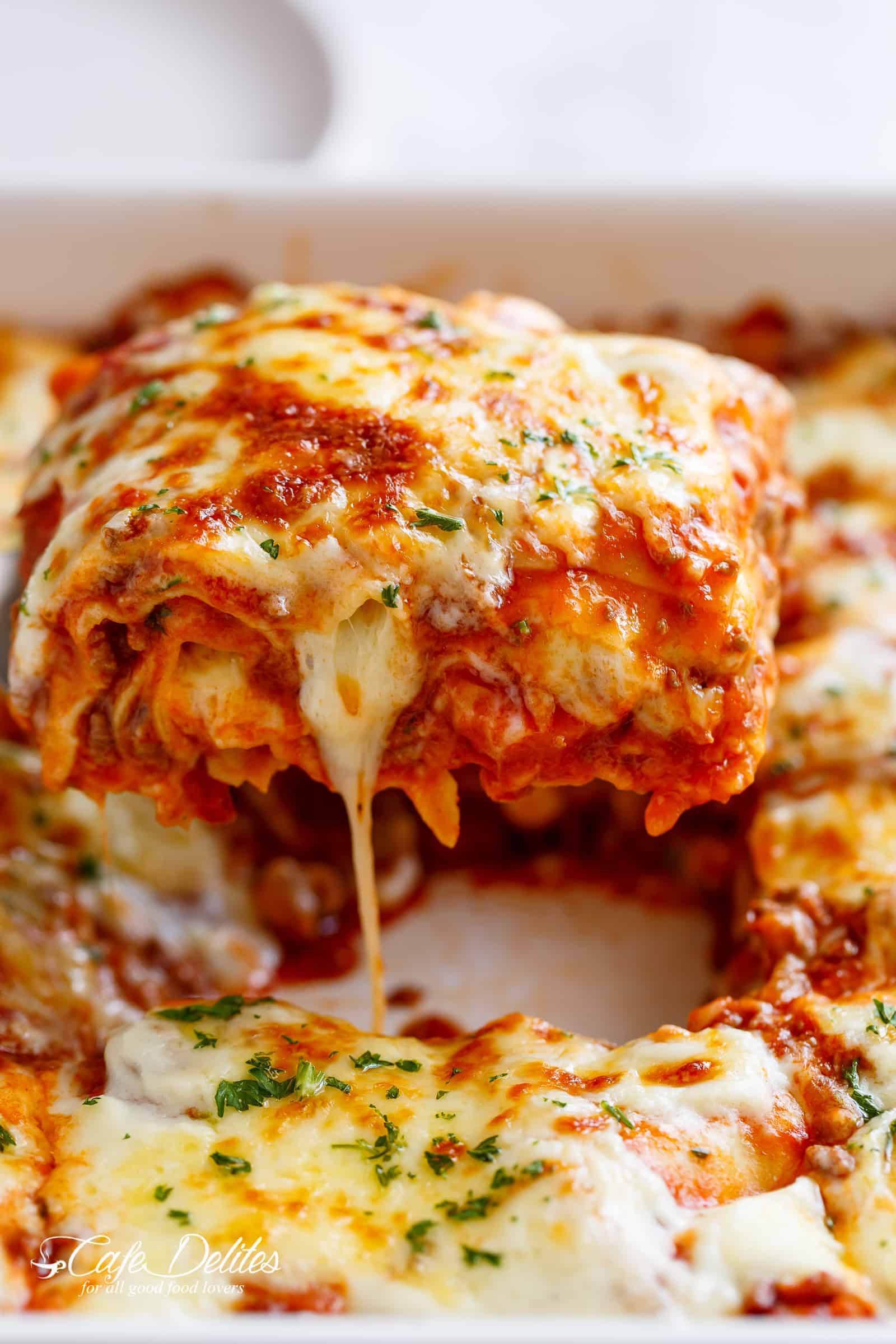 The Best Lasagna is layered with a rich meat sauce and a creamy parmesan white sauce, plus the perfect amount of mozzarella cheese! | cafedelites.com